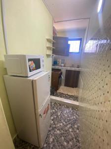 a room with a refrigerator with a microwave on top of it at Modern 1-Bedroom Apartment with AC & Parking along Mtwapa Beach Road in Mtwapa