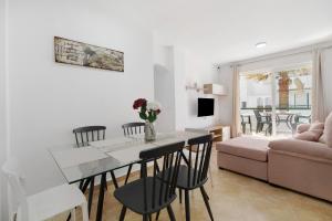 a living room with a table and chairs and a couch at Barrosamar - Primera línea de playa in Chiclana de la Frontera