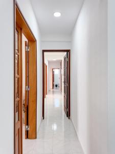 a hallway with white walls and wooden doors at Refúgio Urbano com Acesso Fácil às Praias in Lagos