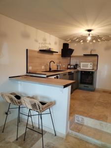 cocina con 2 taburetes y encimera en Saint-Tropez FLORIDA, en Saint-Tropez