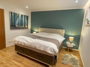 a bedroom with a bed with a blue wall at SONNENWEG Designwohnung mit Gartenblick in Plauen