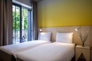 two beds in a room with a window at Melt in Palanga in Palanga