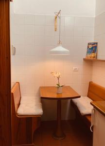a kitchen with a table with a vase of flowers on it at Le Residenze dei Serravallo in Trieste
