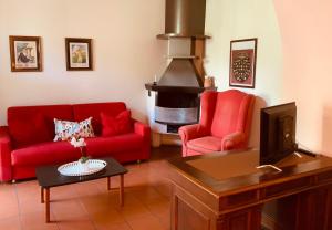 salon z 2 czerwonymi kanapami i kominkiem w obiekcie Le Residenze dei Serravallo w Trieście
