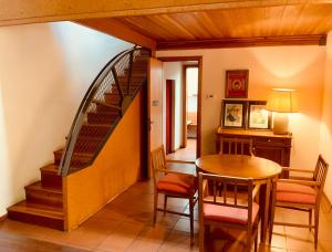 a dining room with a spiral staircase and a table at Le Residenze dei Serravallo in Trieste