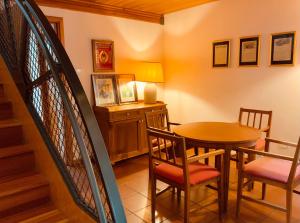 a dining room with a table and chairs and a staircase at Le Residenze dei Serravallo in Trieste