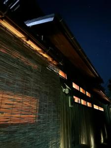a building with lights on the side of it at night at 白子の古民家bimbetta 星空の下で焚き火とバーベキュー in Shirako