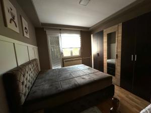 a room with a couch and a window and a bed at Apartman Tadeus in Soko Banja