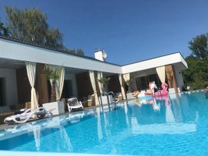 Una gran piscina con sillas y una casa. en Bryza Morska, en Świnoujście