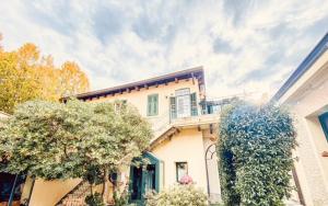 a white house with a balcony on top of it at Le Residenze dei Serravallo in Trieste