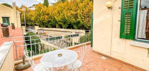 a patio with a table and chairs on a balcony at Le Residenze dei Serravallo in Trieste