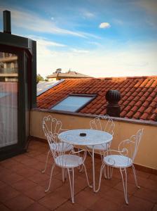 a patio with a table and chairs on a roof at Le Residenze dei Serravallo in Trieste