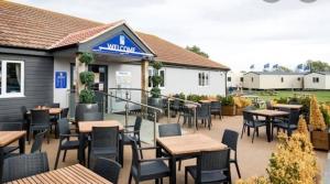 a patio of a restaurant with tables and chairs at Seaview Holiday Rentals - Seawall in Whitstable
