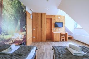 una camera con due letti e una tv di Hotel Jelka Pokljuka a Podjelje