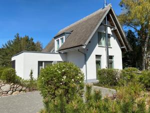 a white house with a gray roof at Ferienhaus am Lotsenstieg 6 in Karlshagen