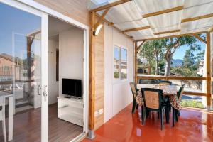 a dining room with a table and chairs and a television at New Generation La pineta 7 in Albenga