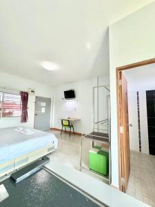 Habitación hospitalaria con cama y TV en โรงแรม ปาล์มเพลส en Ban Wang Phai Tha Kham