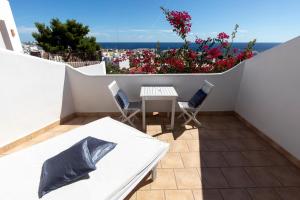 - un balcon avec une table, des chaises et des fleurs dans l'établissement Buenavista & Suites, à Santa Eulària des Riu