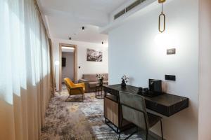 a corridor of a hotel room with a desk and chairs at City Hotel Dubrovnik in Dubrovnik