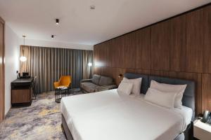 a hotel room with a large bed and a desk at City Hotel Dubrovnik in Dubrovnik