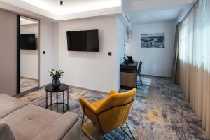a living room with a couch and a television at City Hotel Dubrovnik in Dubrovnik