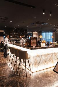 a bar in a restaurant with two chefs preparing food at City Hotel Dubrovnik in Dubrovnik