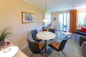 ein Wohnzimmer mit Tisch und Stühlen in der Unterkunft Wohnpark Stadt Hamburg - Apt. 14 in Binz