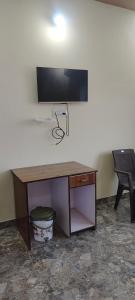 una scrivania con TV a schermo piatto a parete di Bharat hotel a Ambikāpur