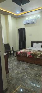 a bedroom with a bed and a chair in a room at Bharat hotel in Ambikāpur