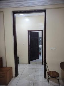 a room with a black door and a table and a chair at Appartement Tout Confort en Centre Ville de Kaloum in Conakry
