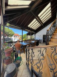 a balcony with a table and chairs and windows at Bedesten Pansiyon in Çeşme