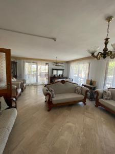 a large living room with couches and a chandelier at Bedesten Pansiyon in Çeşme