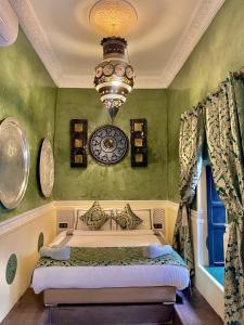 um quarto com uma cama com um relógio na parede em Riad Ta'achchaqa em Marrakech