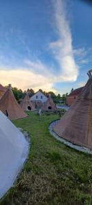 un groupe de tentes dans un champ avec de l'herbe dans l'établissement Kuckunniwi Tipidorf, à Werder