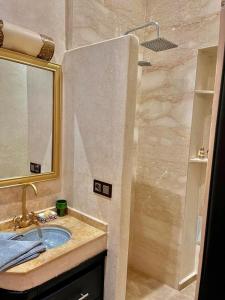 uma casa de banho com um lavatório e um chuveiro em Riad Ta'achchaqa em Marrakech