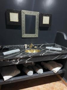 a bathroom counter with a sink and a mirror at Riad Ta'achchaqa in Marrakesh