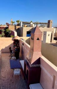 a balcony with a table and chairs on a building at Riad Ta'achchaqa in Marrakesh