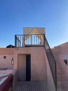 Una escalera que conduce a una casa con balcón en Riad Ta'achchaqa, en Marrakech