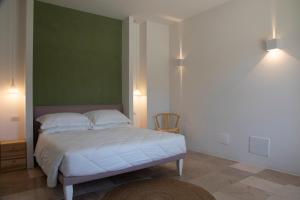 1 dormitorio con 1 cama con pared verde en Masseria Celentano Relais & Agriturismo en San Severo