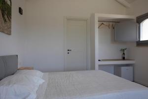 a bedroom with a white bed and a kitchen at Masseria Celentano Relais & Agriturismo in San Severo