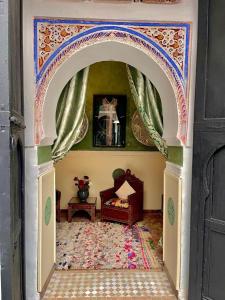 an archway into a room with a bed in it at Riad Ta'achchaqa in Marrakesh
