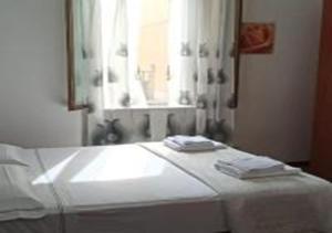Habitación con cama con espejo y ventana en Orbetello Appartamento accogliente con parcheggio gratuito, en Orbetello