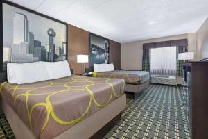 a hotel room with two beds and a tv at Super 8 by Wyndham Grand Prairie North in Grand Prairie