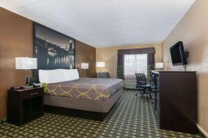 a hotel room with a bed and a desk at Super 8 by Wyndham Grand Prairie North in Grand Prairie