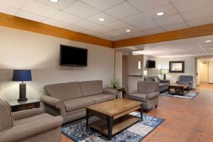 una sala de espera con muebles y TV de pantalla plana. en Travelodge by Wyndham Thunder Bay ON en Thunder Bay