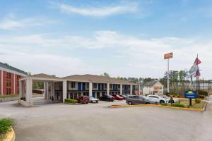 un hôtel avec des voitures garées dans un parking dans l'établissement Days Inn by Wyndham Douglasville-Atlanta-Fairburn Road, à Douglasville
