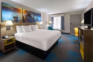 a hotel room with a bed and a flat screen tv at Days Inn by Wyndham Douglasville-Atlanta-Fairburn Road in Douglasville