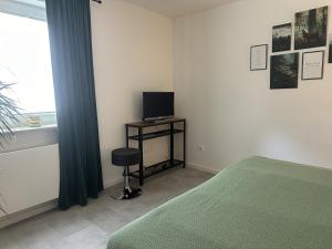 um quarto com uma cama e uma televisão numa mesa em Melanies Apartment em Burgsinn