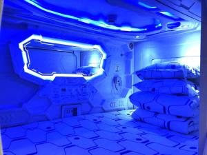 a room with a bed and a blue light at Xi'an Xianyang International Airport Space Capsule Hotel in Xi'an