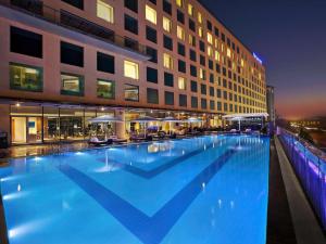 a large swimming pool in front of a building at Novotel Pune Viman Nagar Road in Pune